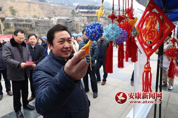2月2日,胡延軍在嵐皋縣就業創業“春風行動”招聘會現場觀賞一家制作手工藝品公司的產品。張昊 攝.jpg
